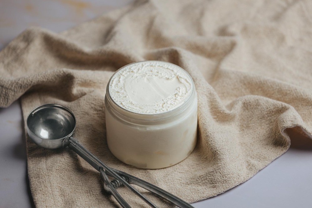 Tarro de helado sobre una tela y un sacabolas