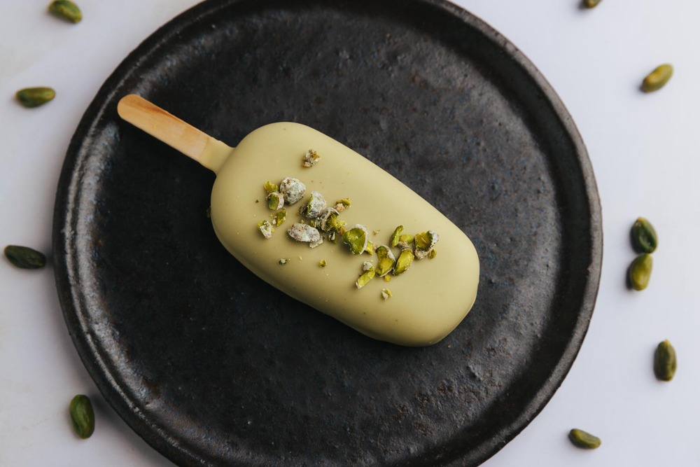 Paleta de helado de pistacho sobre plato negro