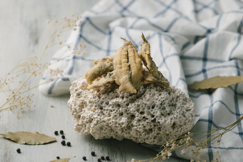Boquerones fritos sobre piedra con mantel de fondo, cómo hacer boquerones en adobo
