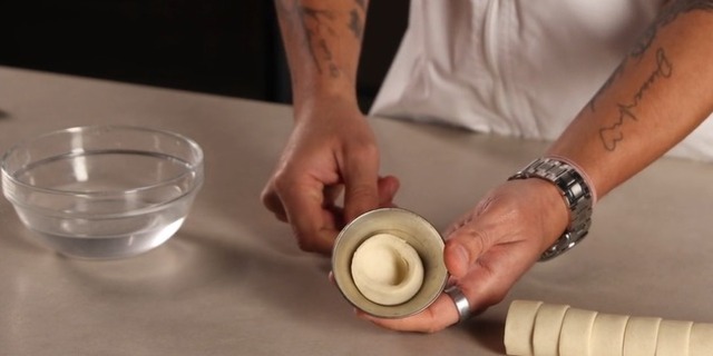 Shape puff pastry into molds for Pastel de Nata